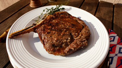 Prime Rib. Special cut with bone of the ox for a delicious barbecue on a white plate