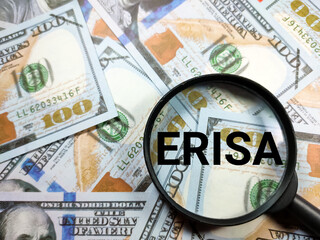 Business concept.Text ERISA with magnifying glass on dollar banknote background.