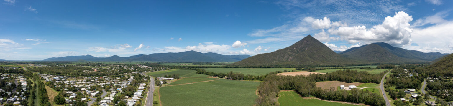 Aerial panoramic view of Walsh's Pyramid mountain and sugar cane fields surrounding the town of Gordonvale in Queensland Australia