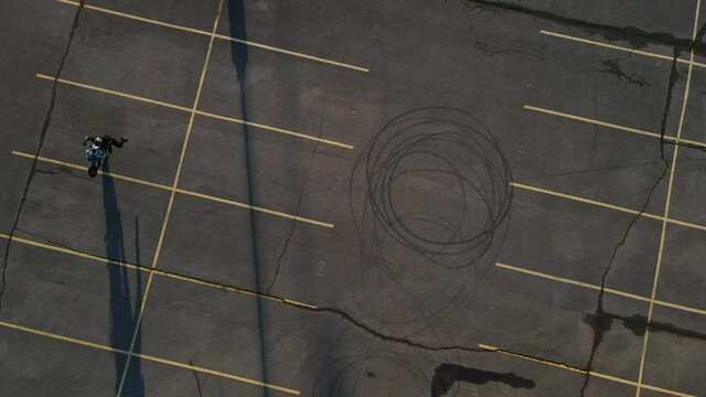 Motorcyclist doing wheelies in an empty parking lot