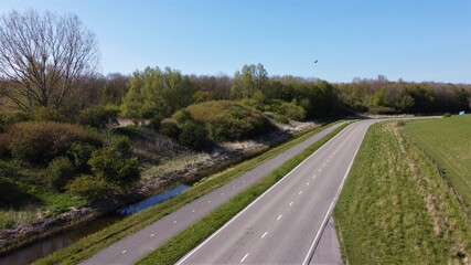 Deserted road in spring, no traffic, no people on the street. Lockdown with lonely moments and quiet outside. Less pollution in nature.