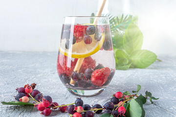 Fresh cool detox drink with berries and lemon. Glass of lemonade or infuse water, tea with leaves mint. Proper nutrition and healthy eating. Fitness diet. Copy space for text