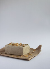 Halva with sunflower seeds on a white background. Image with copy space, vertical orientation, side view.