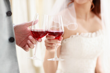 Crop photo the groom giving the bride a glass of wine to the bride in a white lace dress on the day of the wedding to celebrate happily. Concept love best day