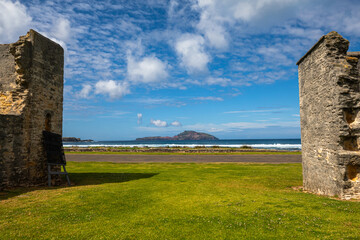 The historical place on Norfolk Island looking out towards the two small islands isolated island in the middle of the Pacific ocean with blue sky and clouds.