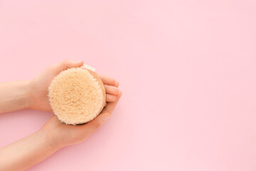 Female hands with massage brush on color background