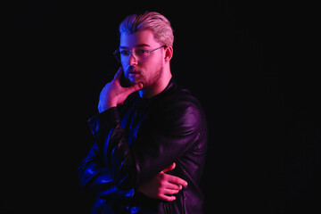 Toned portrait of handsome young man on dark background