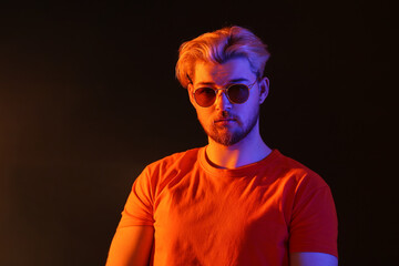 Toned portrait of handsome young man on dark background