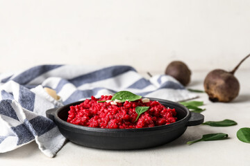 Frying pan with tasty beet risotto on light background