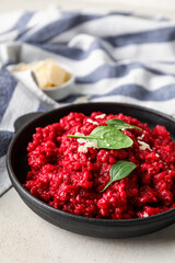 Frying pan with tasty beet risotto on light background