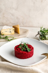 Plate with tasty beet risotto on light background