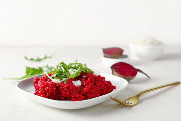 Plate with tasty beet risotto on light background
