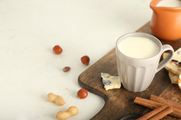Cup with hot white chocolate on light background