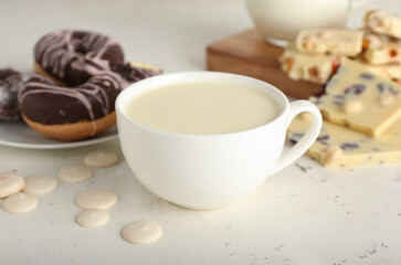 Fototapeta na wymiar Cup with hot white chocolate on light background