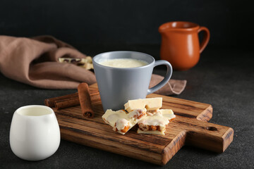 Cup with hot white chocolate on dark background