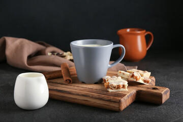 Cup with hot white chocolate on dark background