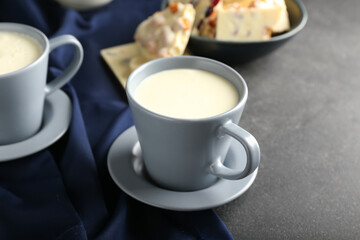 Cup with hot white chocolate on dark background