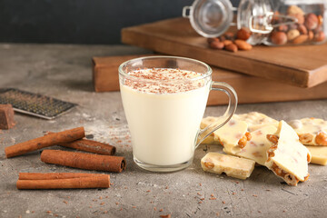 Cup with hot white chocolate on grey background