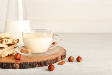 Cup with hot white chocolate on light background