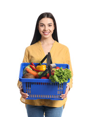 Young woman with shopping basket on white background