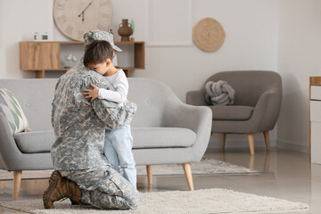 Soldier and his little son hugging at home