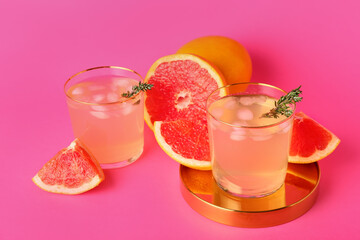 Glasses of tasty grapefruit lemonade on color background