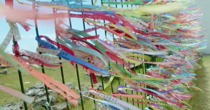 Closeup of colorful ribbons in Bahia, Brazil. Man hand making an request with Brazilian ribbons. Faith. 6K.