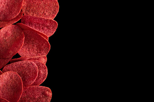 Red Potato Chips With Salt, Chilli And Crab Isolated On A Black Background.