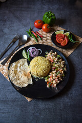  Indian lunch food ingredients pulao, paneer and roasted papad along with salad condiments with use of selective focus