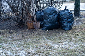 Black plastic garbage bags in the park, spring cleaning.
