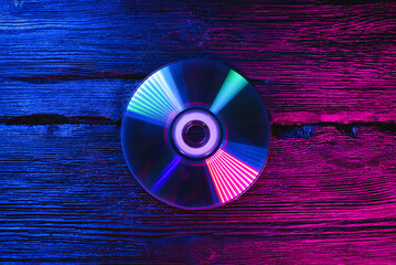 Compact disc on the table in the neon lights.