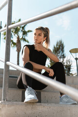 Athletic woman relaxing after summer street workout