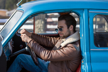 a man sitting in a retro car