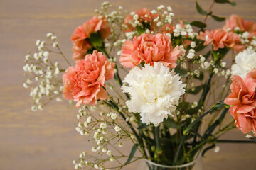 Bouquet of beautiful carnation flowers on wooden background, closeup