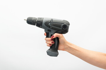 Female hand holds drill isolated on white background. Feminism concept
