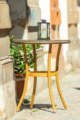 Lantern on a small coffee table,  street cafe, sunny day.