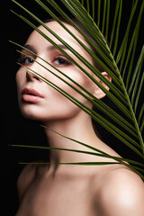 beautiful girl with palm leaves. Beautiful young woman