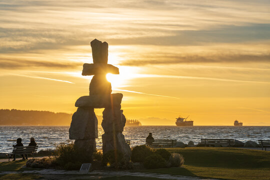 Inukshuk stone sculpture in the sunset time at English Bay Beach, Vancouver City beautiful landscape. British Columbia, Canada.