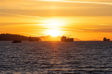 Obraz premium Sunset time at English Bay Beach and ships parked on the ocean. Vancouver City beautiful landscape. British Columbia, Canada.