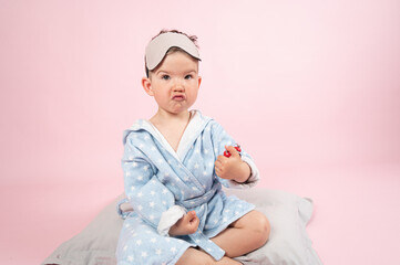 Cute kid boy wearing sleeping mask on pink background. Morning concept