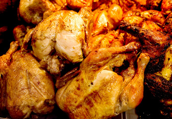 Grilled chickens cooked, whole chicken fried, many piled in bulk, in supermarket.