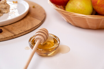 Liquid organic honey on a special spoon of honey in a bowl on a white background Close-up. Healthy food concept.