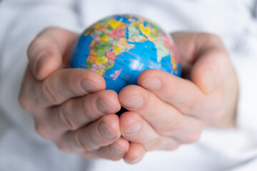 hands holding the ground. Earth globe in hands on a white background close up