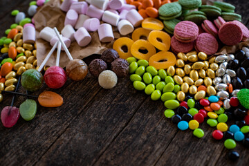 Bowl of candies and chocolate on the wooden table