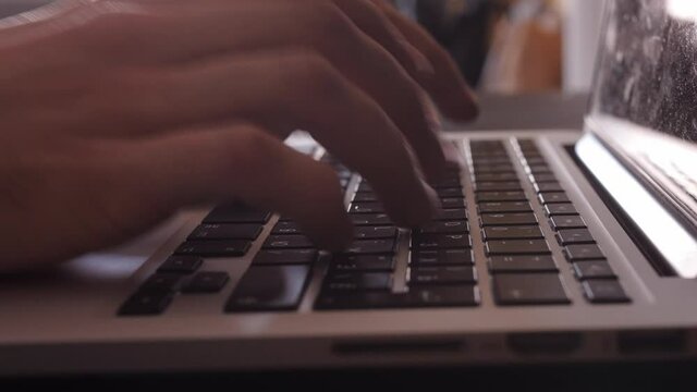 Male hands of programmer or freelancer user worker using typing on laptop notebook keyboard sit at home office desk working online with pc software apps technology concept, close up side view