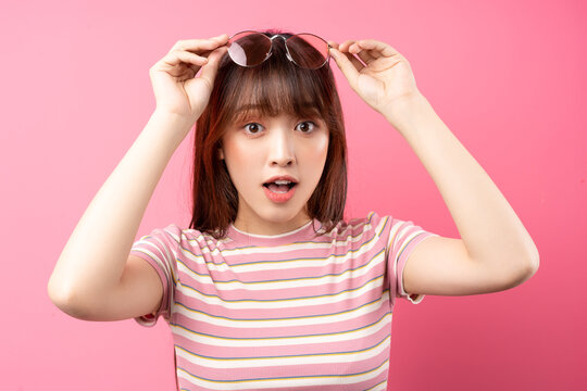 Image of young Asian girl wearing pink t-shirt on pink background