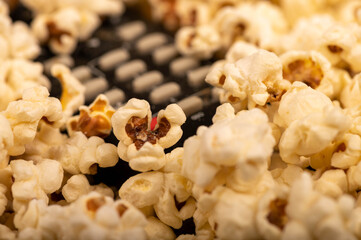 Popcorn scattered on the table and a remote control from the TV. Self-isolation in the covid-19 pandemic.