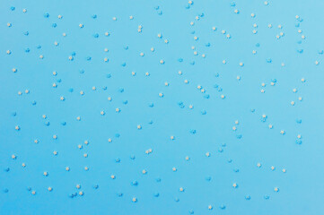 sugar sprinkles in the form of stars on blue background, congectionary decoration. copy space for text