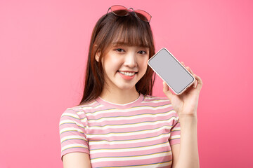 Image of young Asian girl wearing pink t-shirt on pink background