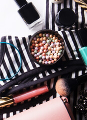 Stylized feminine flatlay with glasses, foundation, lip gloss,